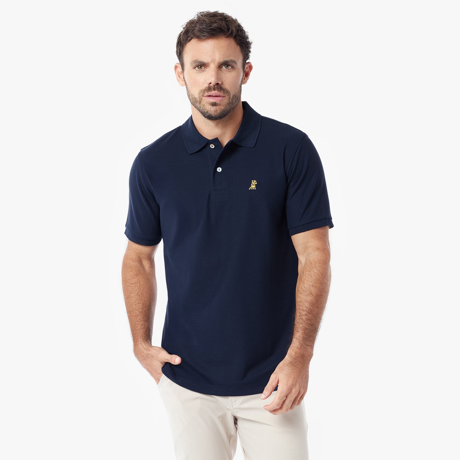 A man wearing a navy blue short-sleeve polo shirt with a small embroidered logo on the chest