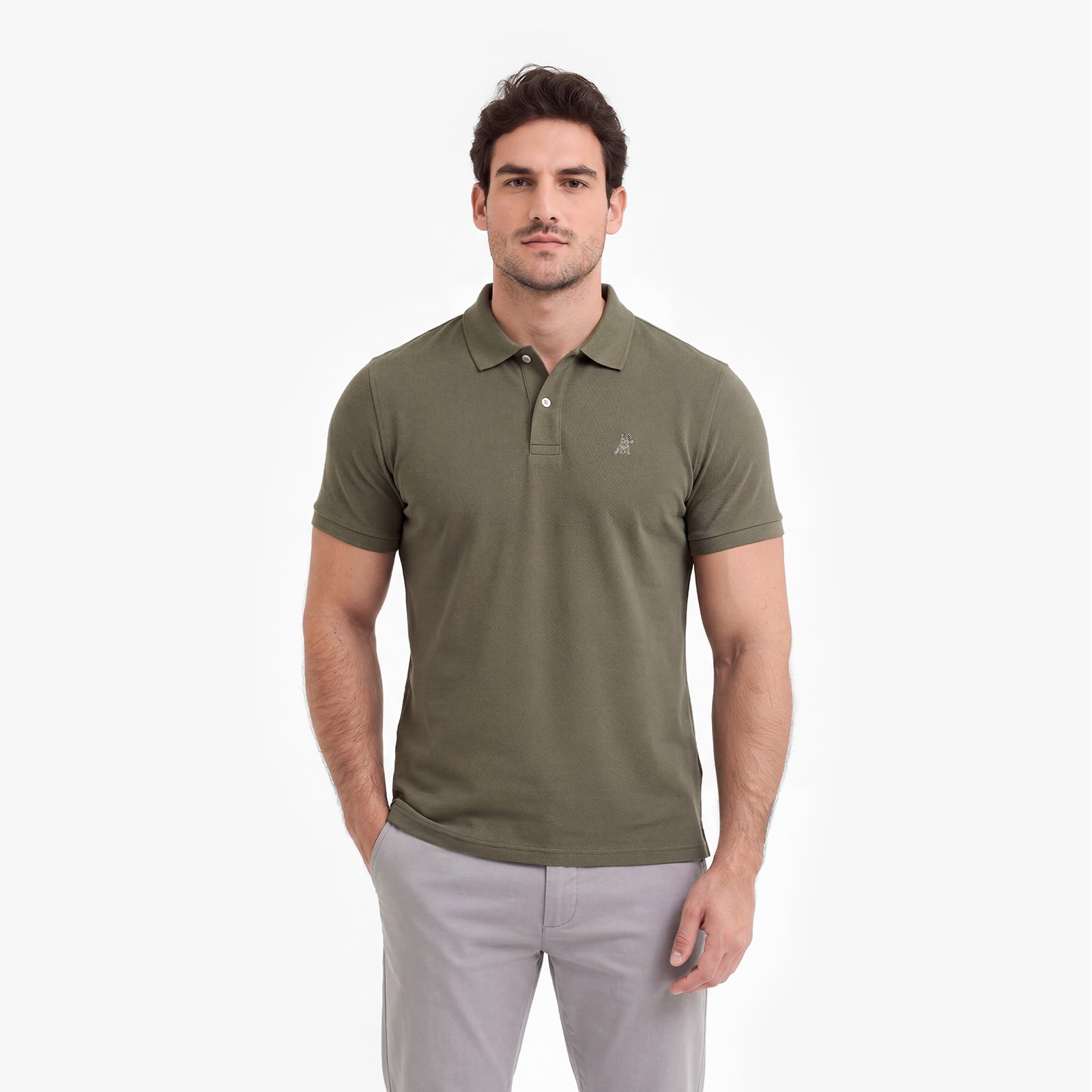 Man wearing a green polo shirt and light gray pants on a white background