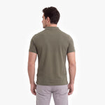 Man wearing a green polo shirt on a white background