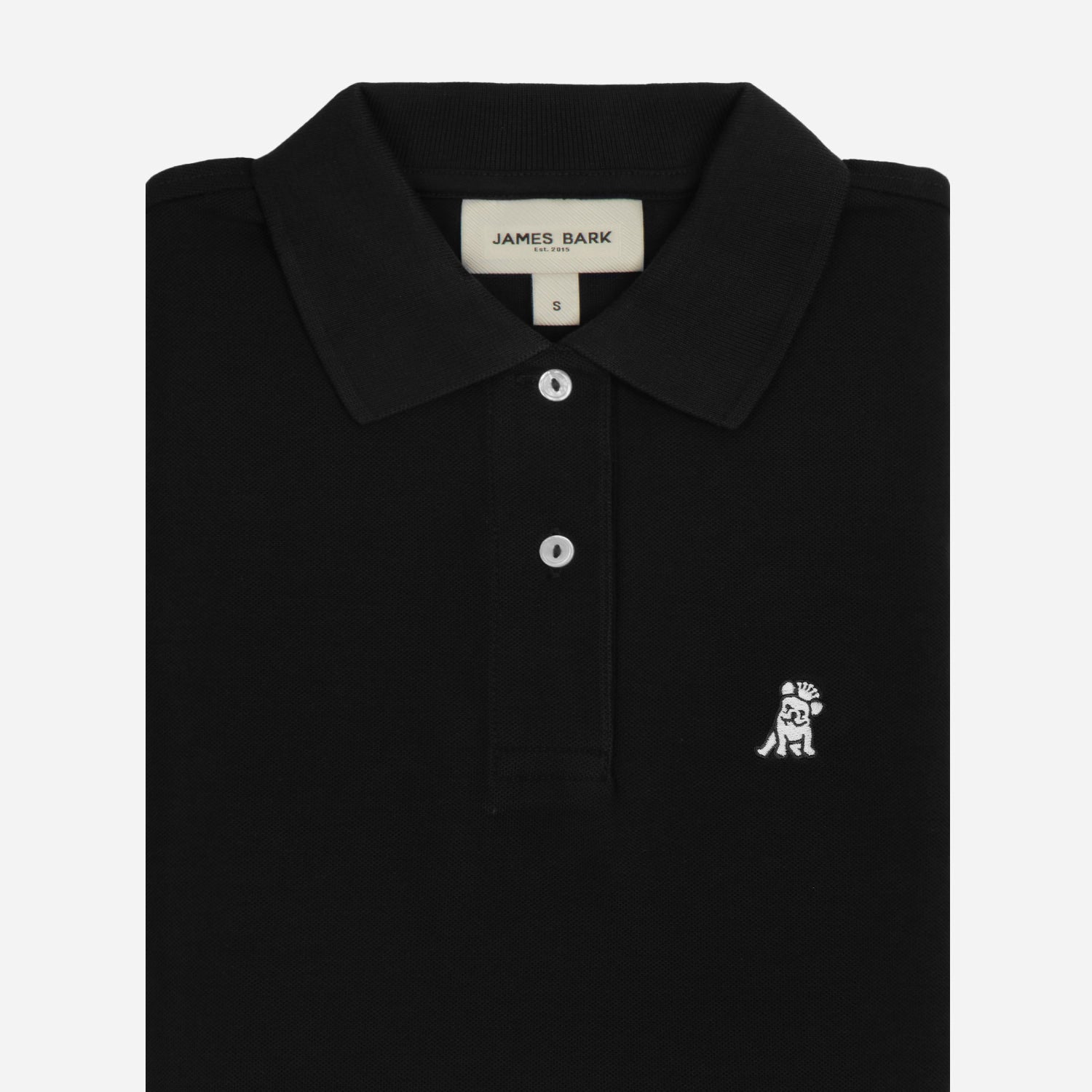 Close-up of the woman's chest area, highlighting the embroidered logo and button detail on the black polo shirt.