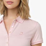Close-up detail shot of the light pink pique polo shirt collar, white buttons on the placket, and the tonal pink embroidered logo on the chest