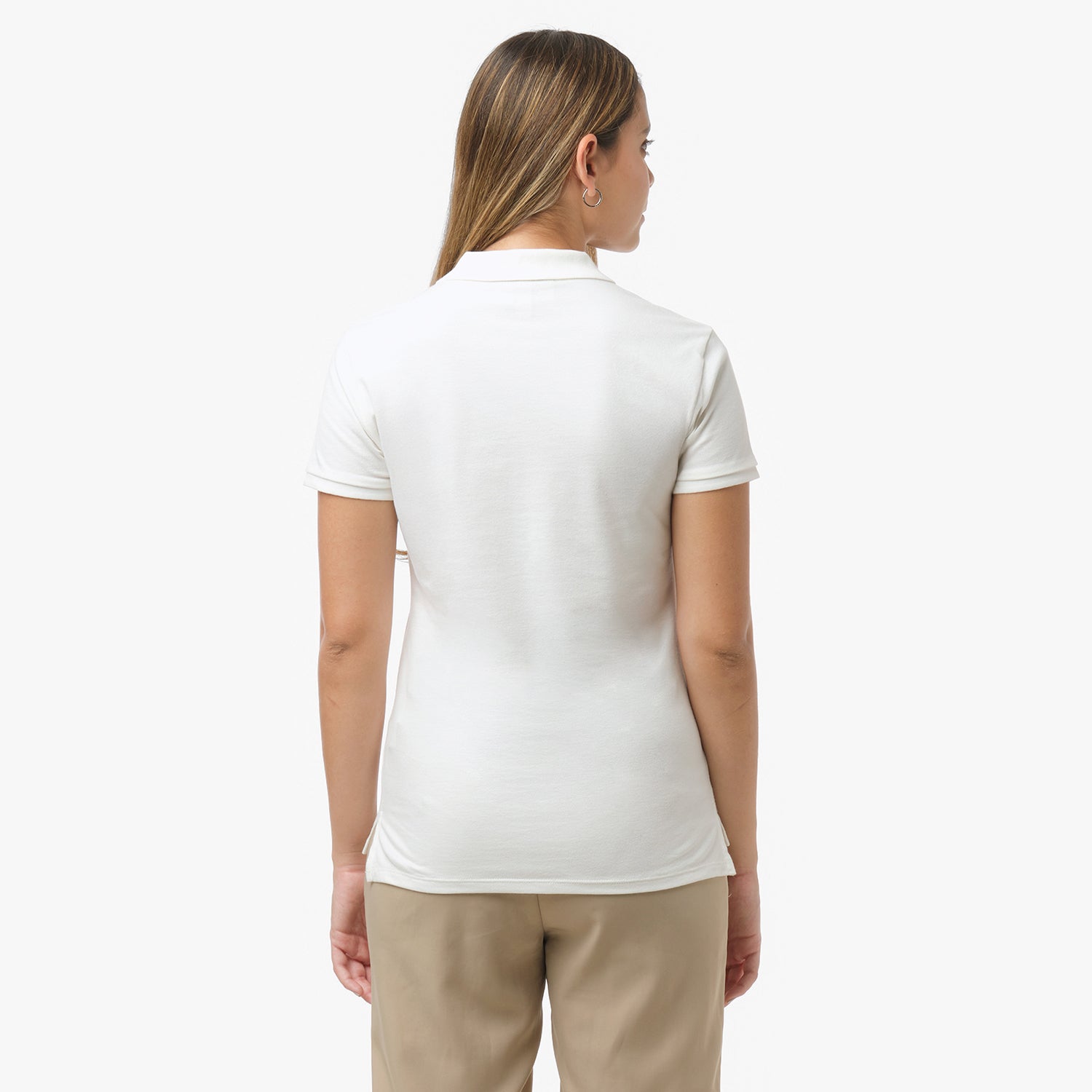 Back view of a woman wearing a short-sleeved off-white polo shirt and beige trousers against a white background