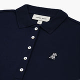 Close-up of the chest, highlighting the collar and white logo on the navy blue polo shirt.