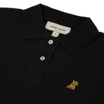 Flat-lay front view of the black polo shirt showing the buttoned collar and gold embroidered logo.
