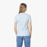 Back picture of a woman wearing a light blue polo shirt and jeans on a white background