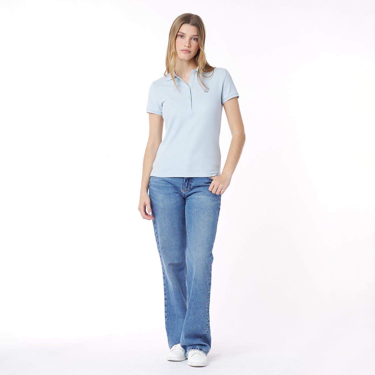 Full body picture of a woman wearing a light blue polo shirt and jeans on a white background
