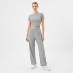 Woman wearing a gray athletic outfit on a white background