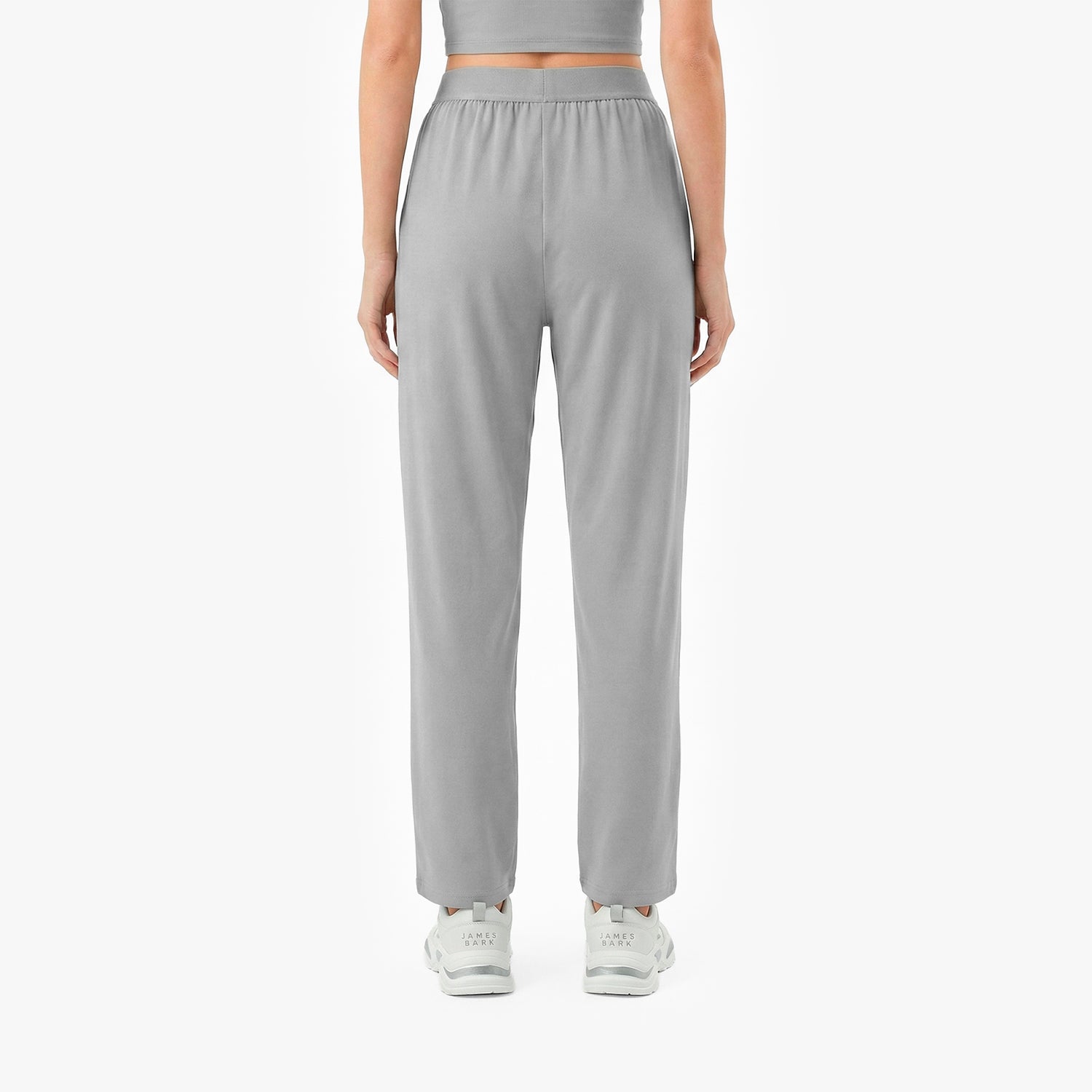 Person wearing gray high-waisted pants on a white background