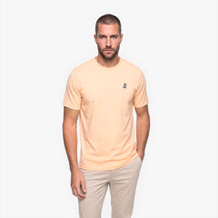 Man wearing a beige t-shirt and pants on a white background
