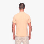 Man wearing a beige polo shirt and pants on a white background