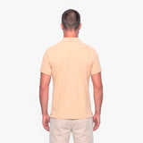Man wearing a beige polo shirt and pants on a white background