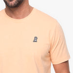 Beige t-shirt with a small logo on the chest against a white background
