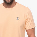 Beige t-shirt with a small logo on a white background