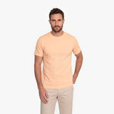 Man wearing a beige t-shirt and pants on a white background