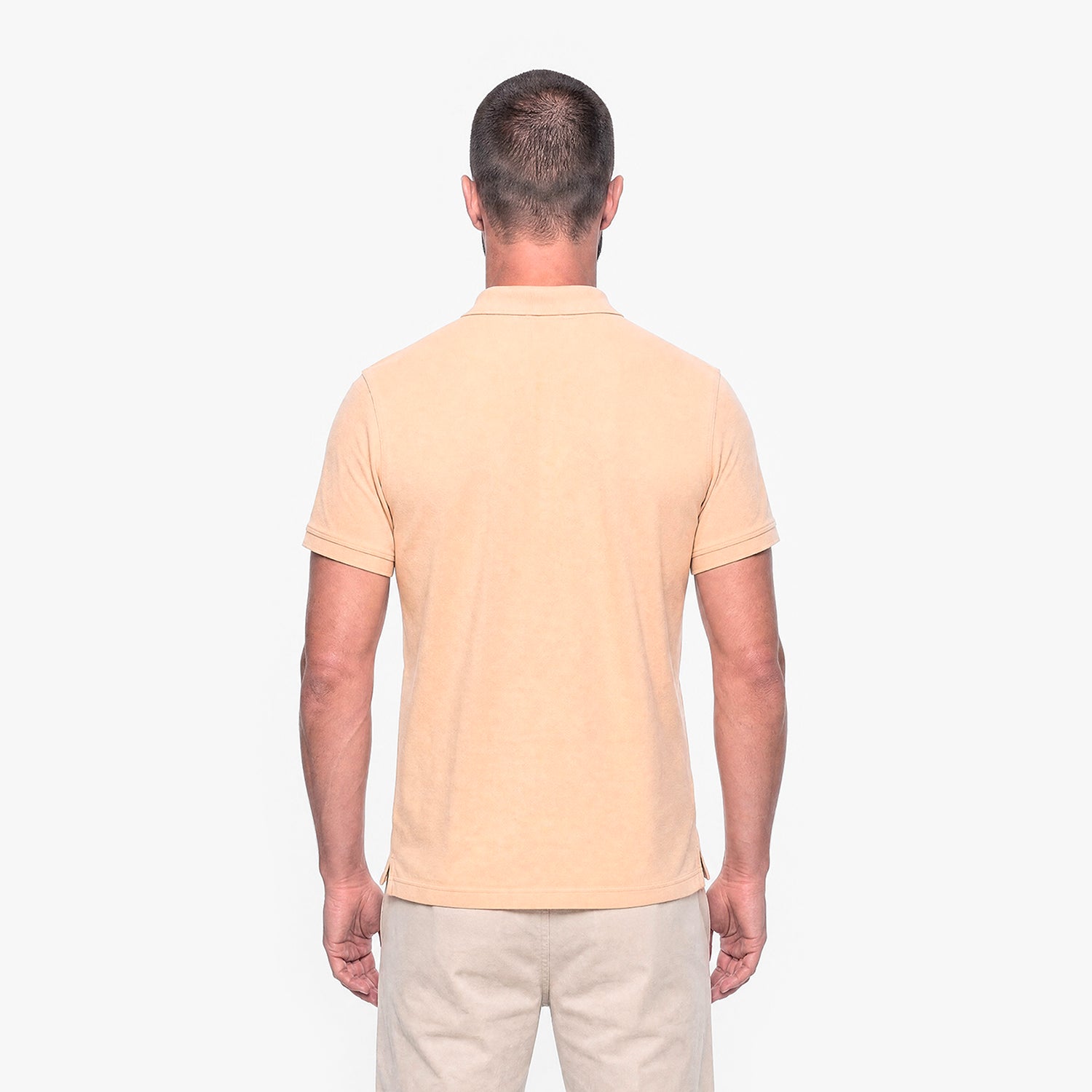 Man wearing a beige polo shirt on a white background