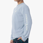 Side picture of the light blue long-sleeve rashguard with 'James Bark' branding on a white background