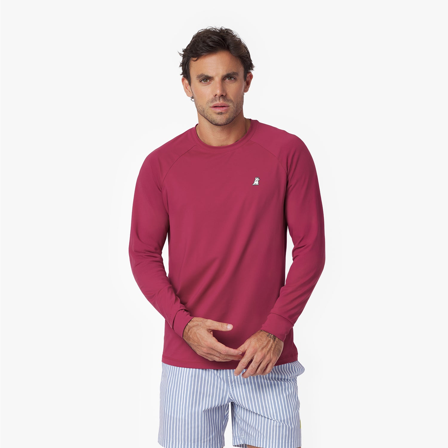 Man wearing a maroon long-sleeve rashguard and light blue striped shorts