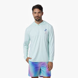 Man wearing a light blue rashguard and tie-dye shorts on a white background