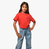 Full-body shot of the girl wearing the red T-shirt and blue jeans, standing with one hand on her hip.