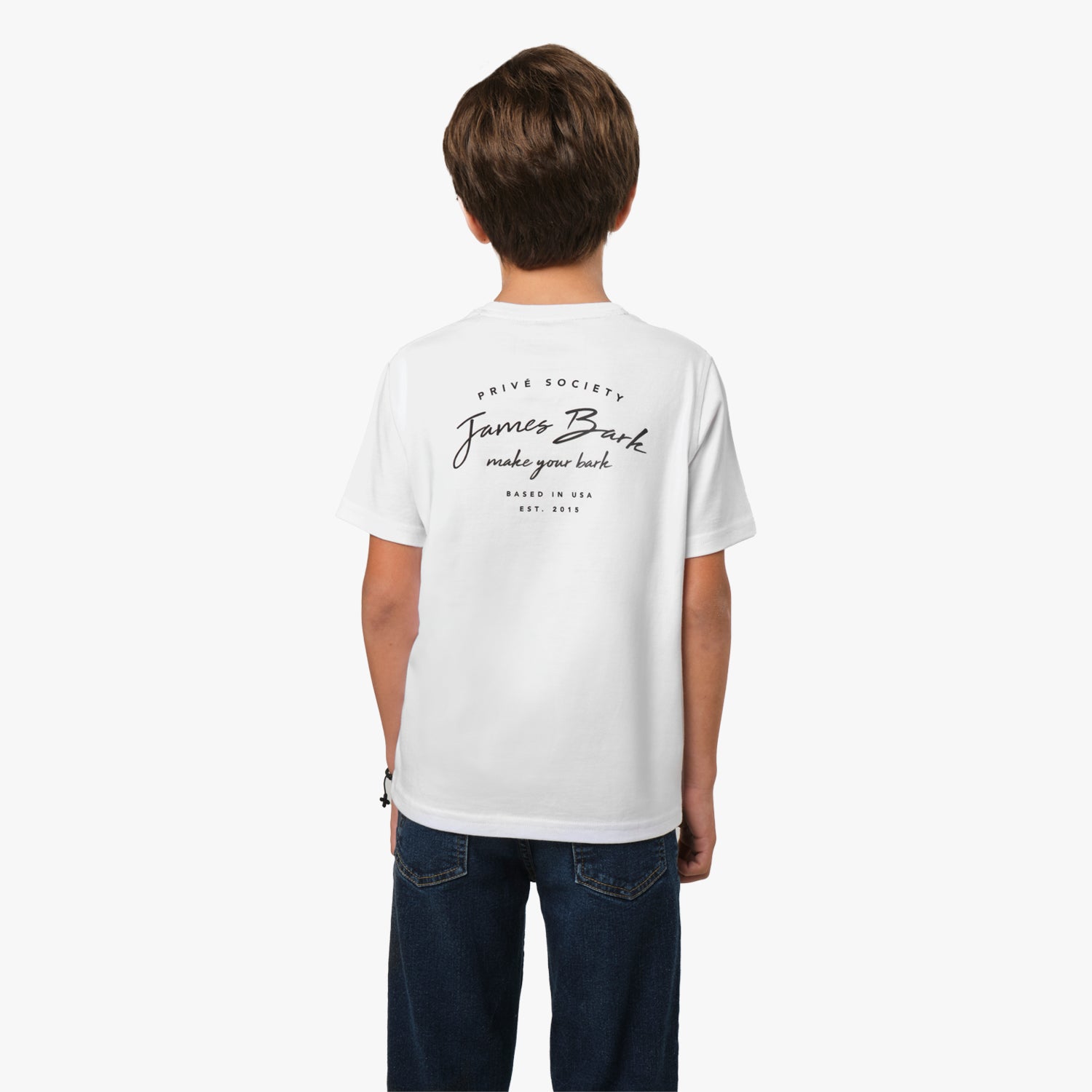 Rear view of a young boy wearing a white T-shirt with a cursive text graphic on the back, paired with jeans.