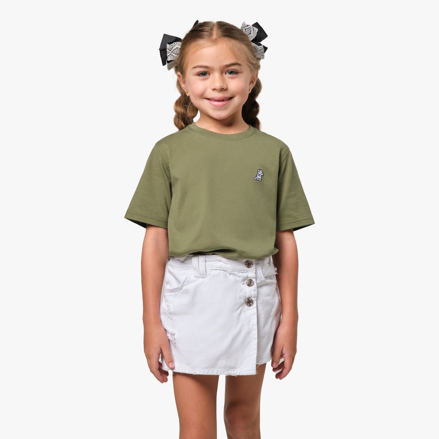 Front view of the girl wearing the olive green T-shirt with a small embroidered logo on the chest, paired with white shorts.