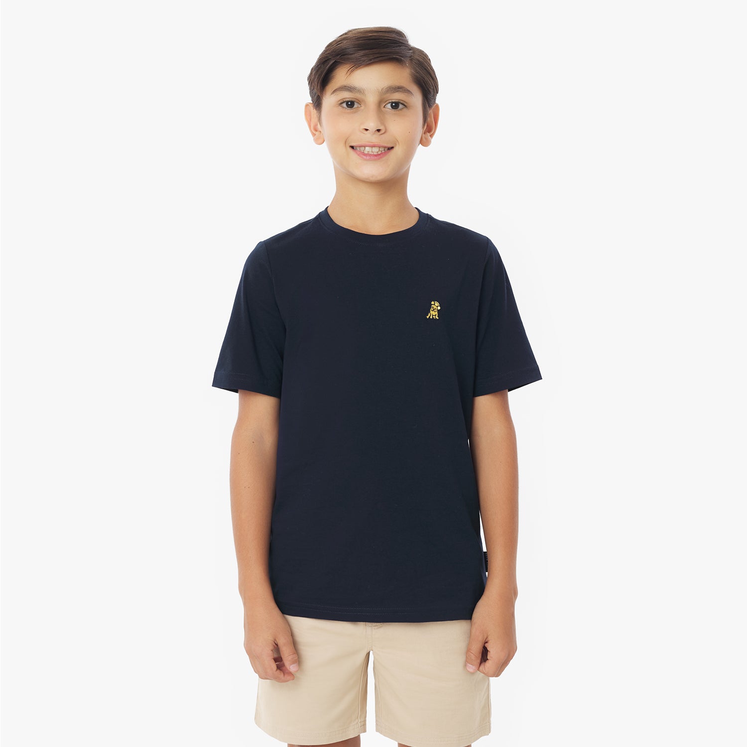 Front view of a young boy wearing a navy blue short-sleeved t-shirt with a yellow logo and khaki shorts, standing against a white background