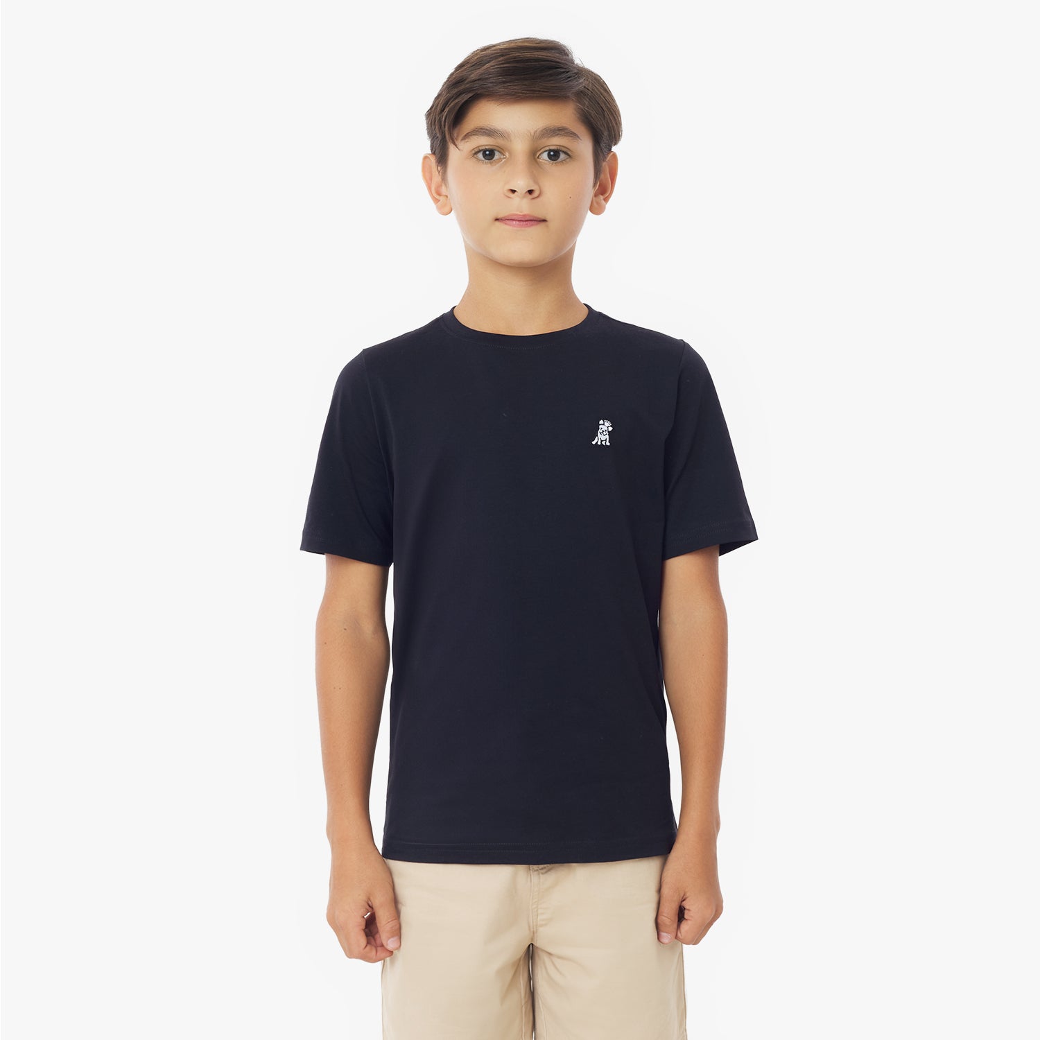 Front view of a young boy wearing a navy blue short-sleeved t-shirt with a white logo and khaki shorts, standing against a white background