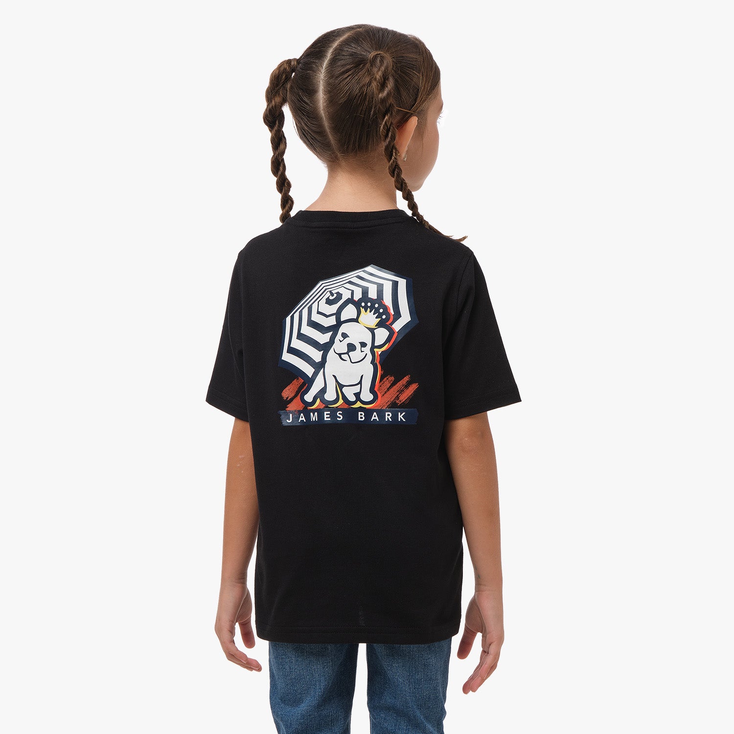 Back view of a young girl wearing a black T-shirt with a graphic of a dog holding an umbrella and the text 'James Bark' on the back, paired with blue jeans