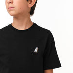 Close-up side view of the boy wearing the black T-shirt, highlighting the small decorative 'JB' logo on the chest.