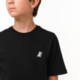 Close-up side view of the boy wearing the black T-shirt, highlighting the small decorative 'JB' logo on the chest.