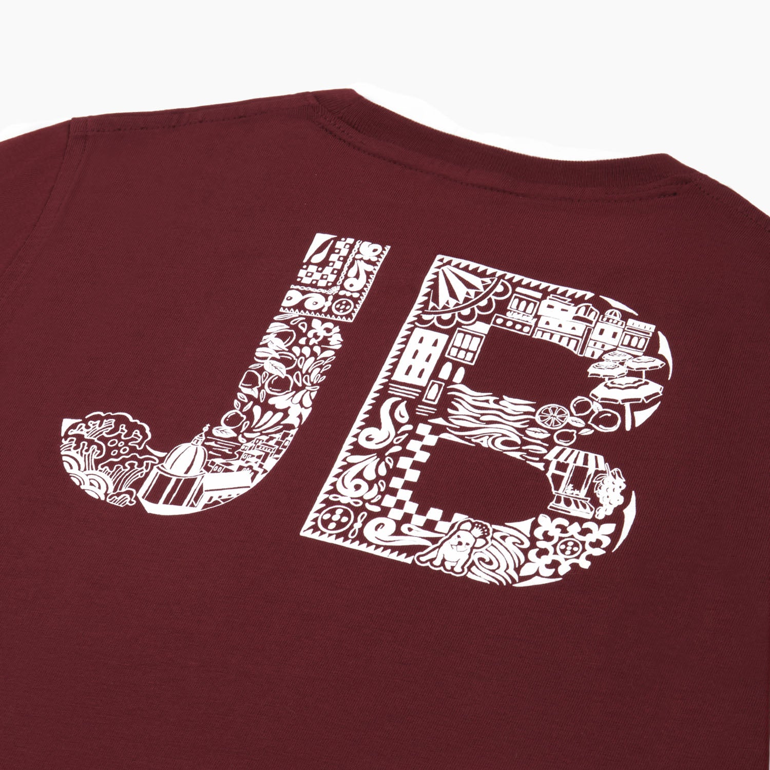 Close-up of the back of the maroon t-shirt, showing the "JB" lettering with a white pattern.