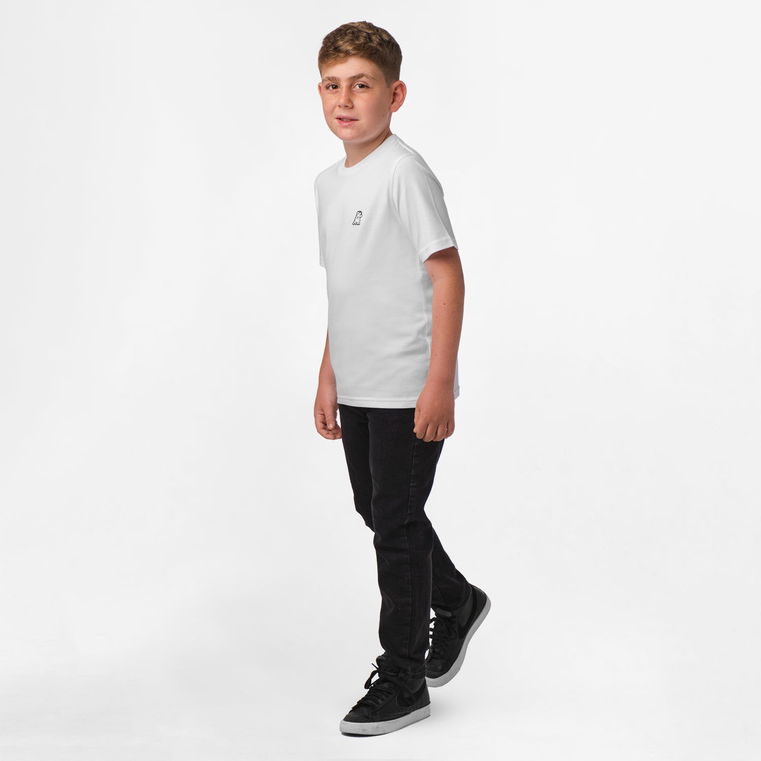 Boy standing while wearing the white t-shirt and black pants, facing forward.