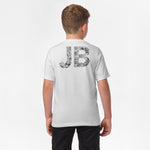 Rear view of a boy wearing a white t-shirt with large "JB" lettering on the back, filled with a black pattern.