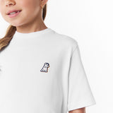 Close-up side view of the girl wearing the white T-shirt, highlighting the small decorative 'JB' logo on the chest.