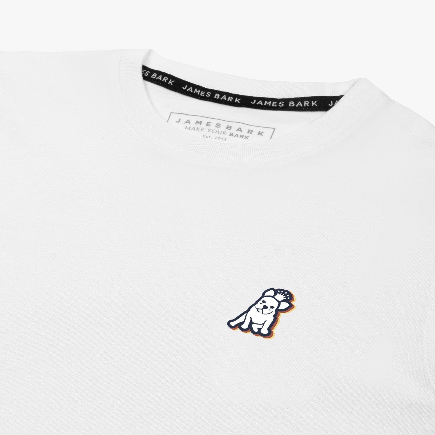 Close-up of the neckline and small decorative 'JB' logo on the chest of the white T-shirt.