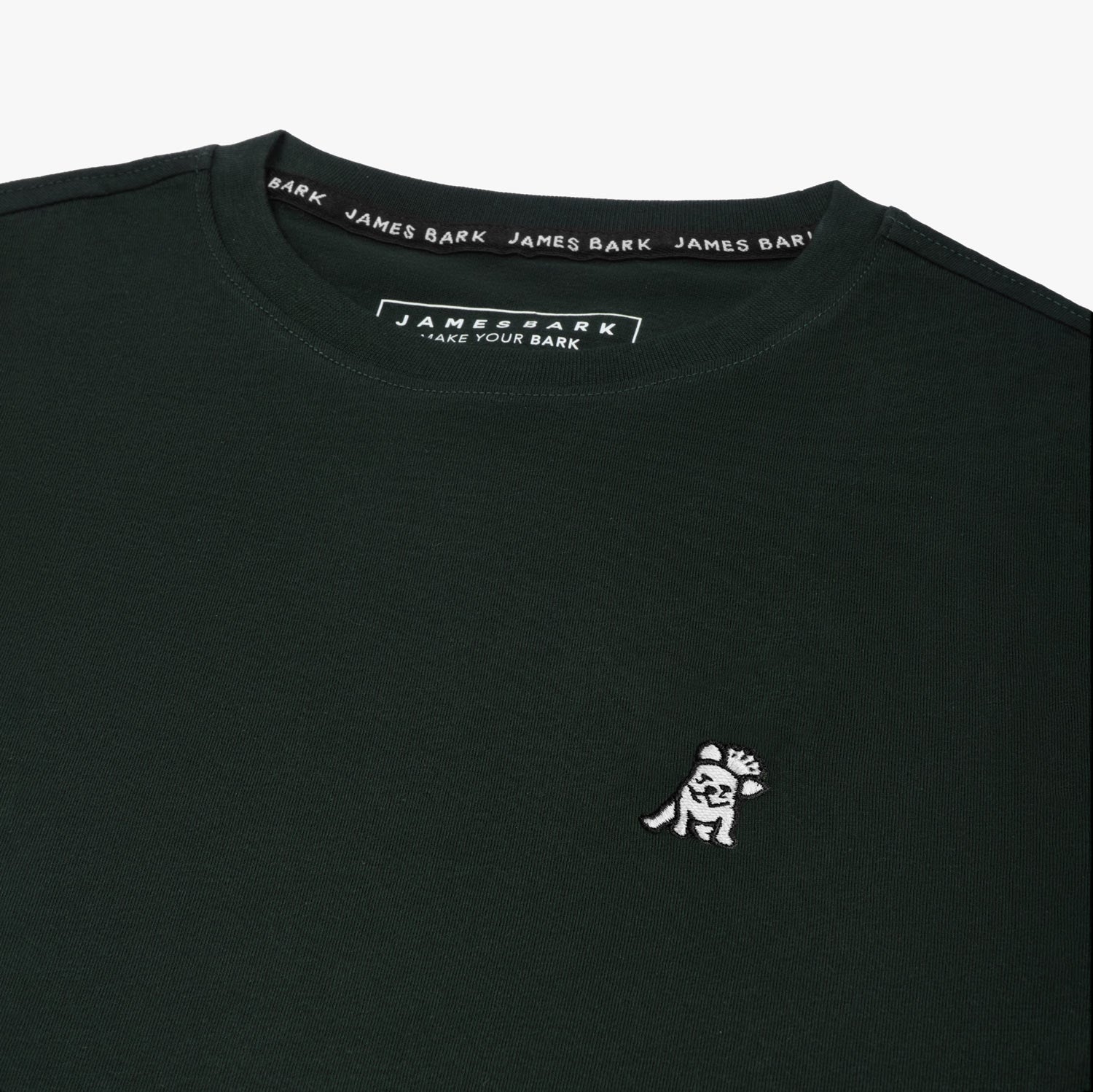 Close-up of the small white embroidered logo on the front of the black t-shirt.