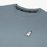 Close-up of the small embroidered logo on the front of the gray t-shirt.