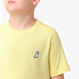 Close-up side view of a boy wearing the yellow T-shirt, highlighting the small dog graphic on the chest.