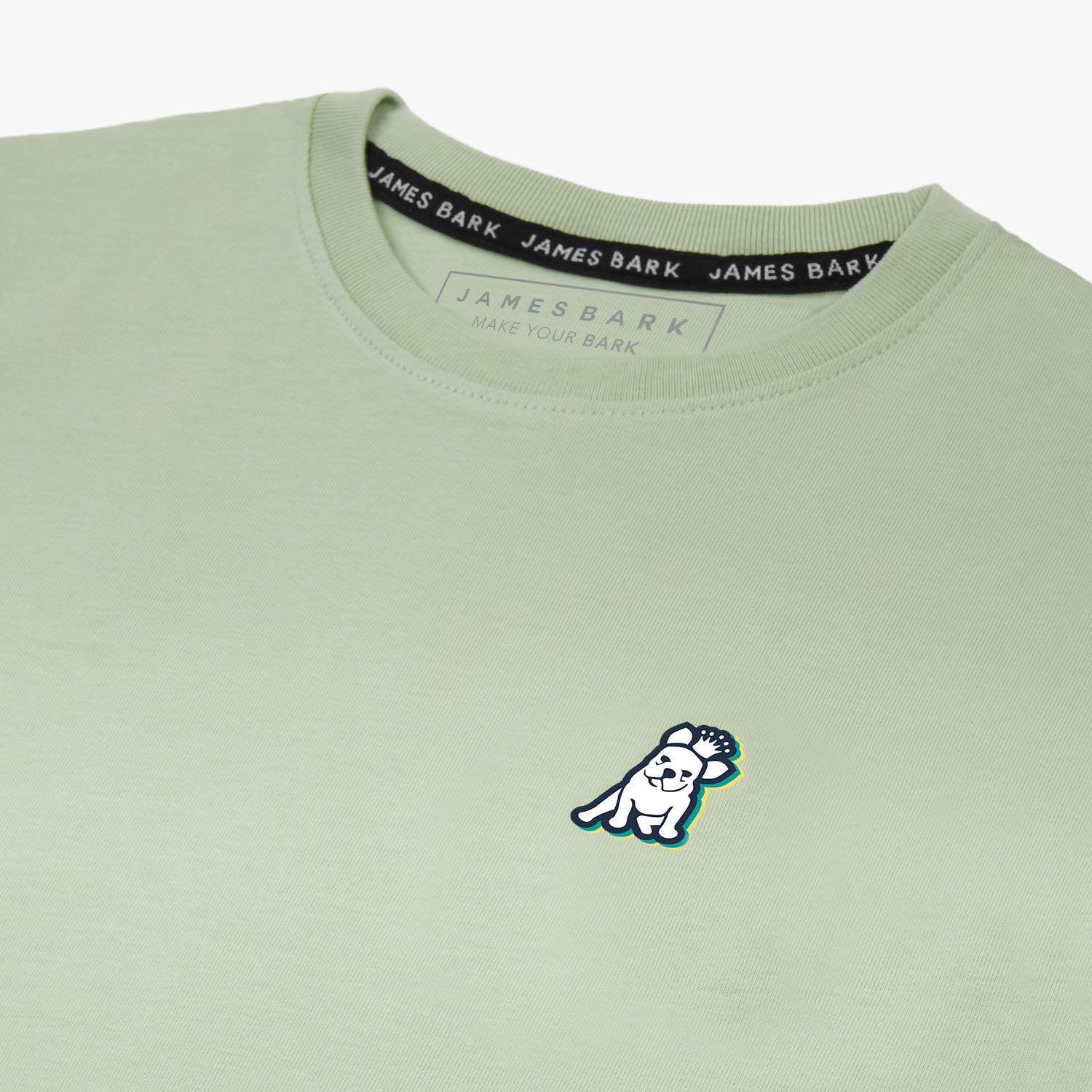 Close-up of the back graphic on the light green T-shirt, showing a dog wearing sunglasses in a colorful circular design with text around it.