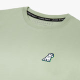 Close-up of the back graphic on the light green T-shirt, showing a dog wearing sunglasses in a colorful circular design with text around it.