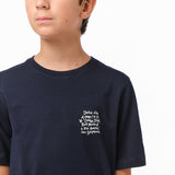 Close-up side view of the boy wearing the navy blue T-shirt, highlighting the text graphic on the chest.