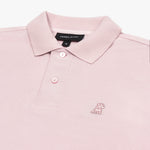 Detailed close-up of the light pink embroidered dog logo on a pink polo shirt