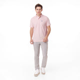Male model wearing a pink polo shirt and light grey pants, walking forward towards the camera