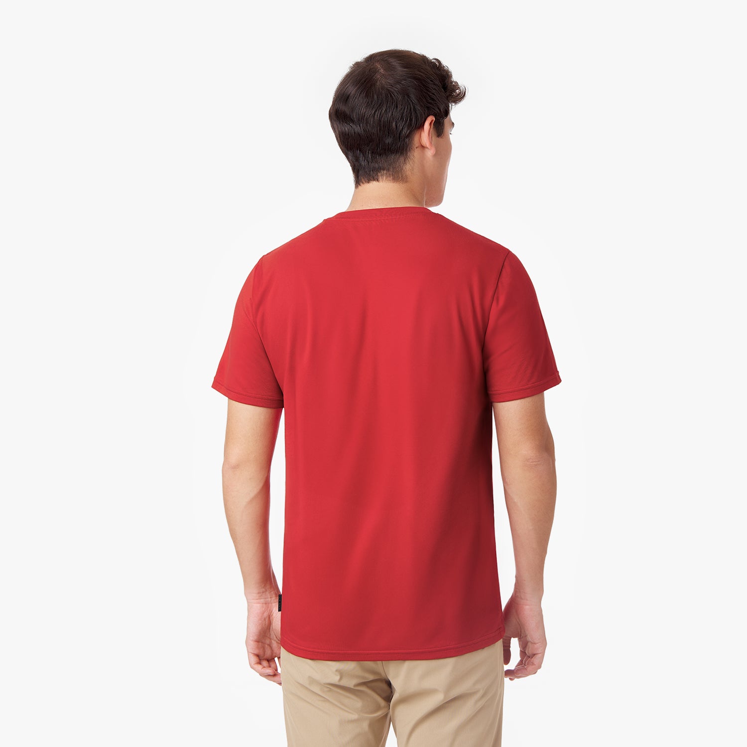 Back view of a male model wearing a red short-sleeved t-shirt and tan pants