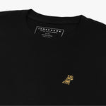 Close-up of the inner label and embroidered logo on the black t-shirt: A detailed shot showing the inner neck label with branding and care information, as well as the small gold embroidered dog logo on the left chest.