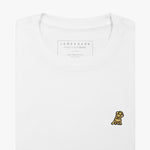 Close-up of the chest area of the white t-shirt: A detailed view of the small embroidered dog logo in gold on the left chest, contrasting against the white fabric.