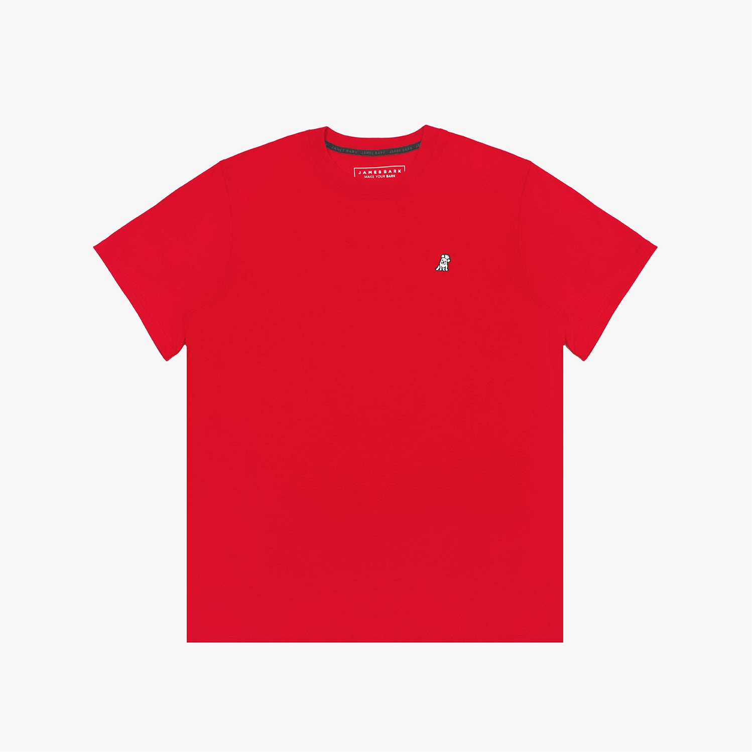 A red short-sleeved T-shirt with a small embroidered white dog logo on the upper left chest area. The neckline has a black inner lining with repeated 'JAMES BARK' branding, and the inside label displays the brand name.