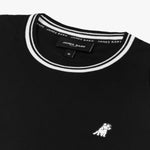 Close-up of the neckline and small dog graphic on the chest of the black T-shirt with white trim.