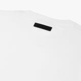 White t-shirt laid flat, showing the back view with the black tag detail visible.