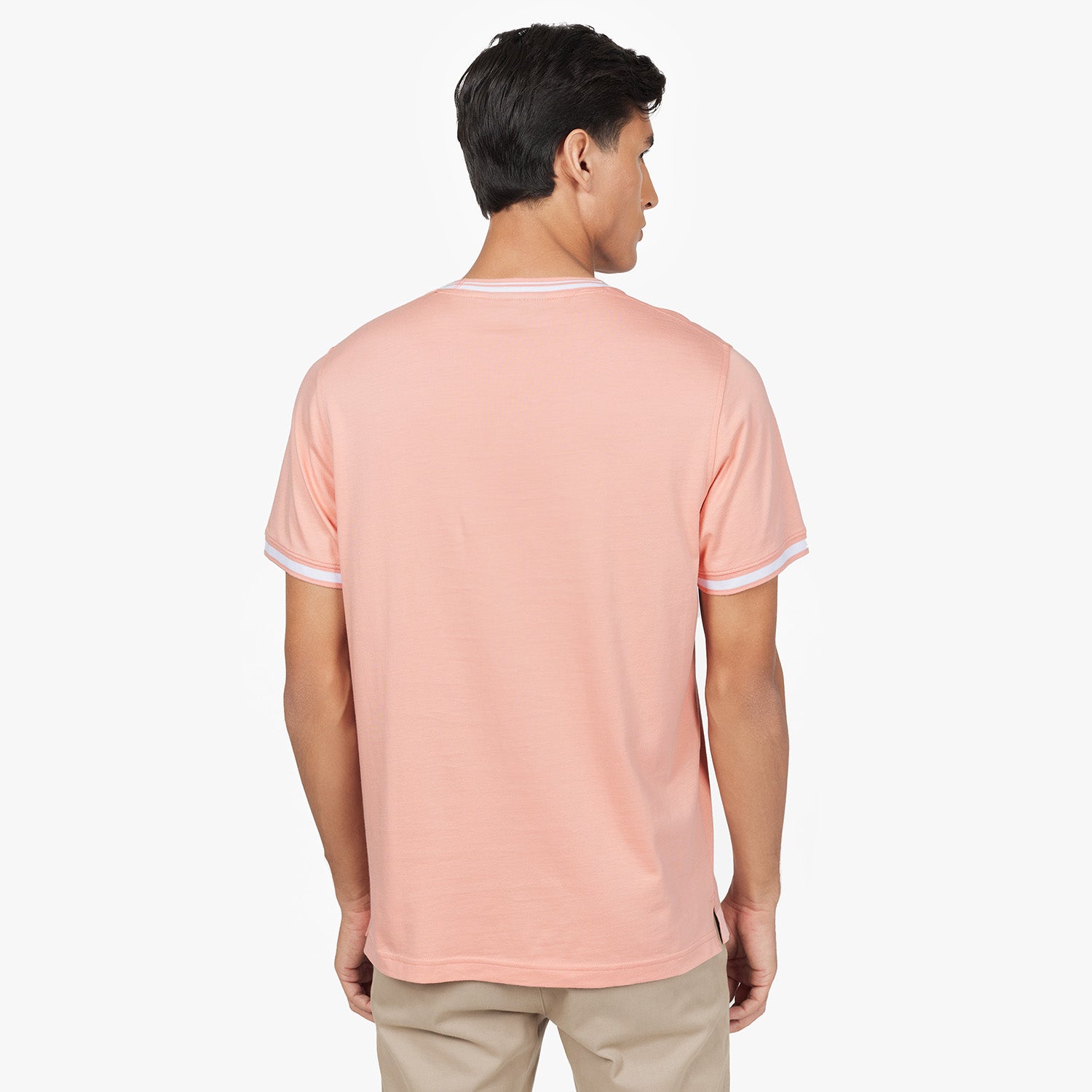 Back view of a man wearing the light pink T-shirt with white trim on the collar and sleeves